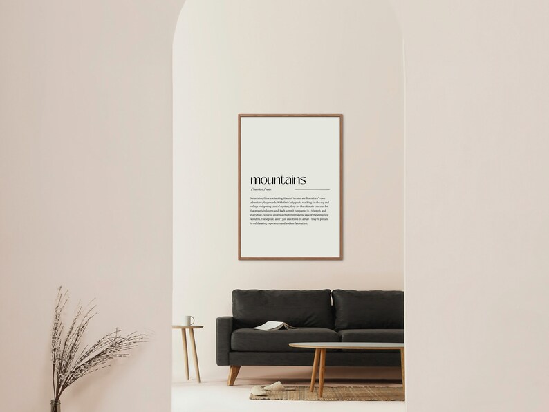 Puede incluir: Una impresi&oacute;n enmarcada con la palabra "monta&ntilde;as" en negrita en negro y una definici&oacute;n de la palabra debajo. La impresi&oacute;n est&aacute; colgada en una pared rosa claro en una habitaci&oacute;n con un sof&aacute; gris y una mesa auxiliar de madera.