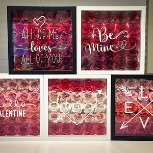 May include: Five framed shadow boxes with different Valentine's Day themed messages and paper flowers. The messages include "All of me loves all of you", "Be Mine", "Hello Valentine", "Love", and a heart with an arrow.
