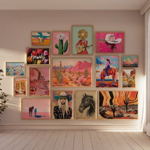 Pode incluir: Uma parede de galeria com uma variedade de obras de arte emolduradas, incluindo um cacto, um chap&eacute;u de cowboy, uma paisagem des&eacute;rtica e uma mulher tocando guitarra. As obras de arte s&atilde;o de v&aacute;rias cores, incluindo rosa, vermelho, verde e azul. A parede &eacute; pintada de uma cor bege claro.