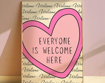 May include: A framed art print with a pink heart design and the words "EVERYONE IS WELCOME HERE" in black. The background is a cream color with the word "Welcome" repeated in a script font.