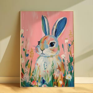 May include: A colorful painting of a rabbit with blue ears and a pink background. The rabbit is surrounded by flowers and greenery.