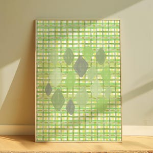 以下が含まれることがあります： 緑と黄色の格子模様を背景に、緑とグレーの色合いのひし形が重ねられた抽象的なアートプリント。明るい色の木製フレームに額装されており、モダンな美しさを演出しています。