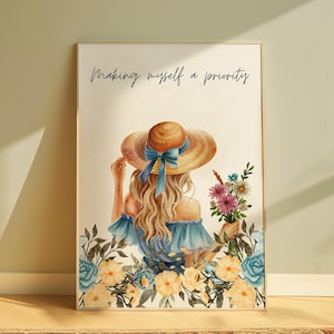 May include: Watercolor print of a woman wearing a large sun hat with a blue bow, holding flowers. The artwork features the text "Making myself a priority" in cursive. Floral border with yellow and blue flowers.
