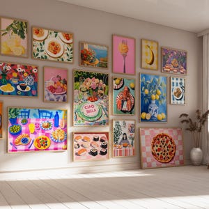 May include: A wall gallery featuring 17 framed prints with a variety of colorful food illustrations. The prints include images of lemons, pasta, sushi, pizza, a lobster, and a cake with the text "Ciao Bella".