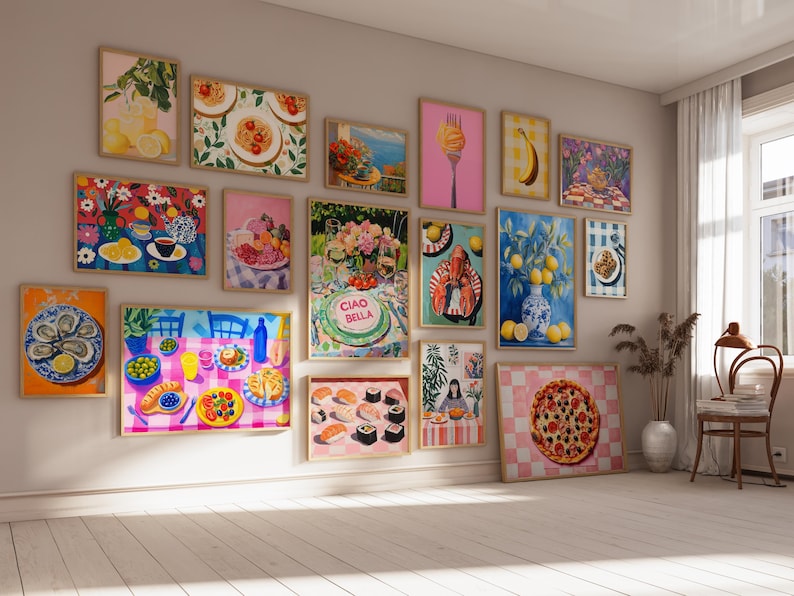 May include: A wall gallery featuring 17 framed prints with a variety of colorful food illustrations. The prints include images of lemons, pasta, sushi, pizza, a lobster, and a cake with the text "Ciao Bella".