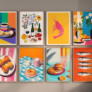 May include: Set of eight colorful framed prints featuring various still life scenes, including a cup of coffee, a bouquet of flowers, a shrimp, a plate of fruit, a burger, a plate of peaches, a donut, and a plate of fish.