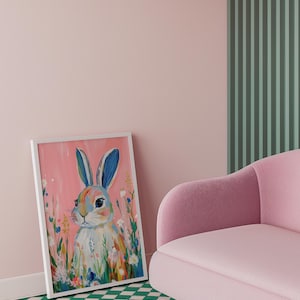 May include: A framed painting of a white rabbit with blue ears surrounded by colorful flowers on a pink background.