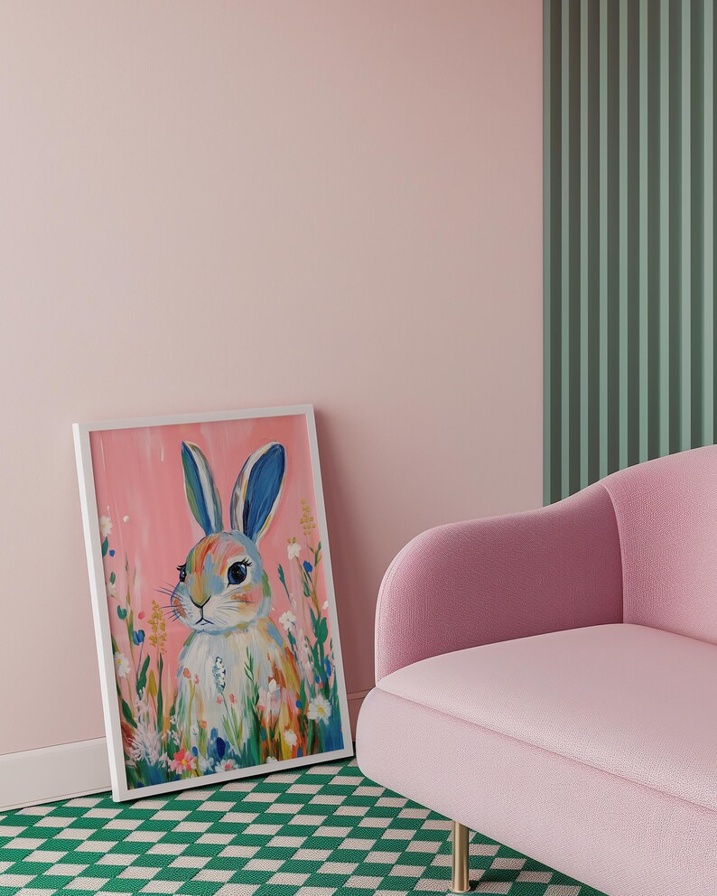 May include: A framed painting of a white rabbit with blue ears surrounded by colorful flowers on a pink background.