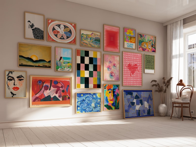 May include: A gallery wall featuring a collection of framed art prints in various sizes and orientations. The display includes abstract, landscape, and figurative illustrations in a diverse color palette, arranged in a grid-like pattern on a wall.