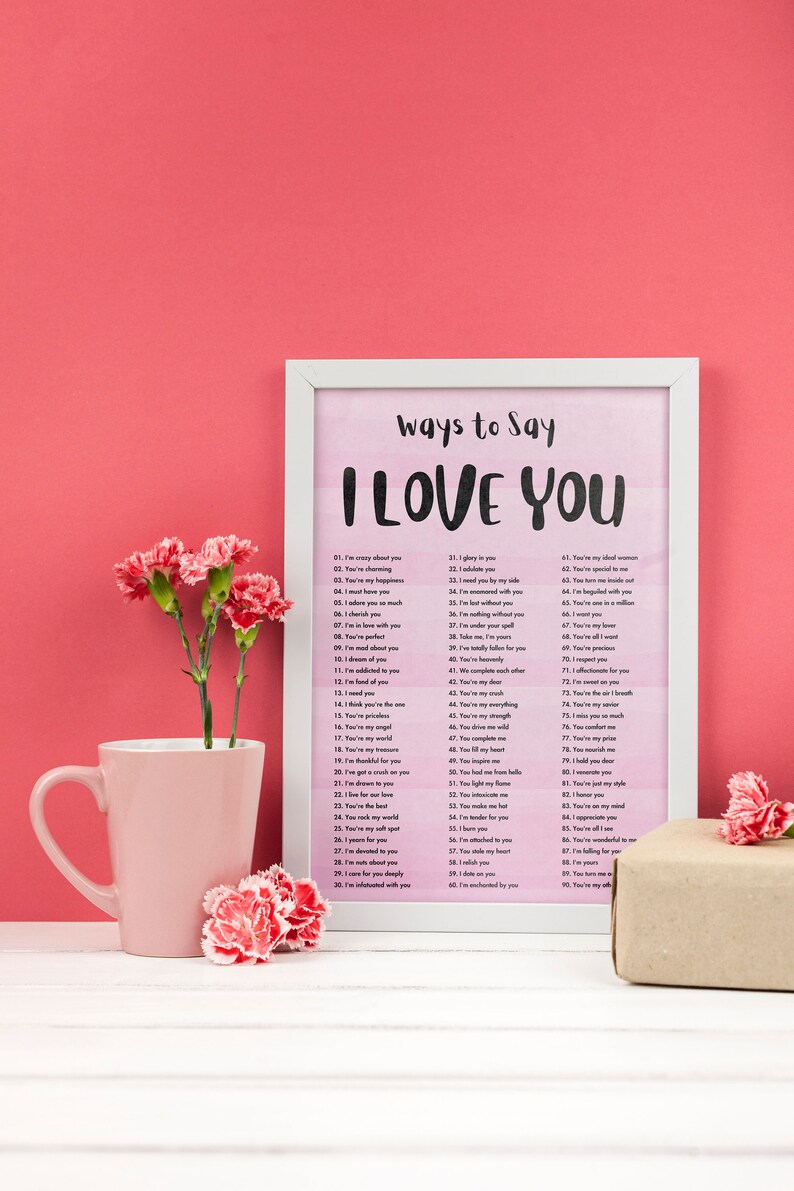 May include: A white framed print with a pink watercolor background and the text "Ways to Say I Love You" with a list of 90 ways to say I love you in black text.