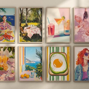 May include: Set of eight framed prints featuring various colorful illustrations. The prints include a woman sitting at a table with food, a table setting in a garden, two cocktails, a glass of wine, a breakfast sandwich, a glass of orange juice, a view from a window, and a woman eating a slice of pizza.