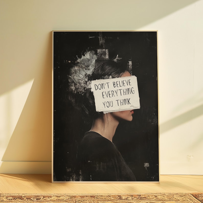 May include: A black and white poster with a woman's face partially obscured by a piece of paper with the text "Don't believe everything you think".