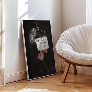 May include: A black and white illustration of a person with a piece of paper covering their face. The paper has the text "Don't believe everything you think" written on it.