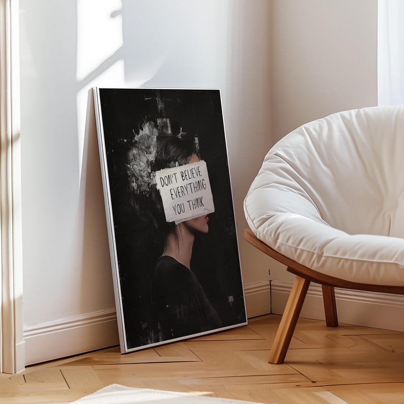 May include: A black and white illustration of a person with a piece of paper covering their face. The paper has the text "Don't believe everything you think" written on it.