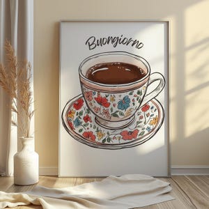 K&ouml;nnte beinhalten: Eine wei&szlig;e Kaffeetasse mit floralem Muster und Untertasse, gef&uuml;llt mit braunem Kaffee. Der Text "Buongiorno" ist in Schwarz &uuml;ber der Tasse geschrieben.