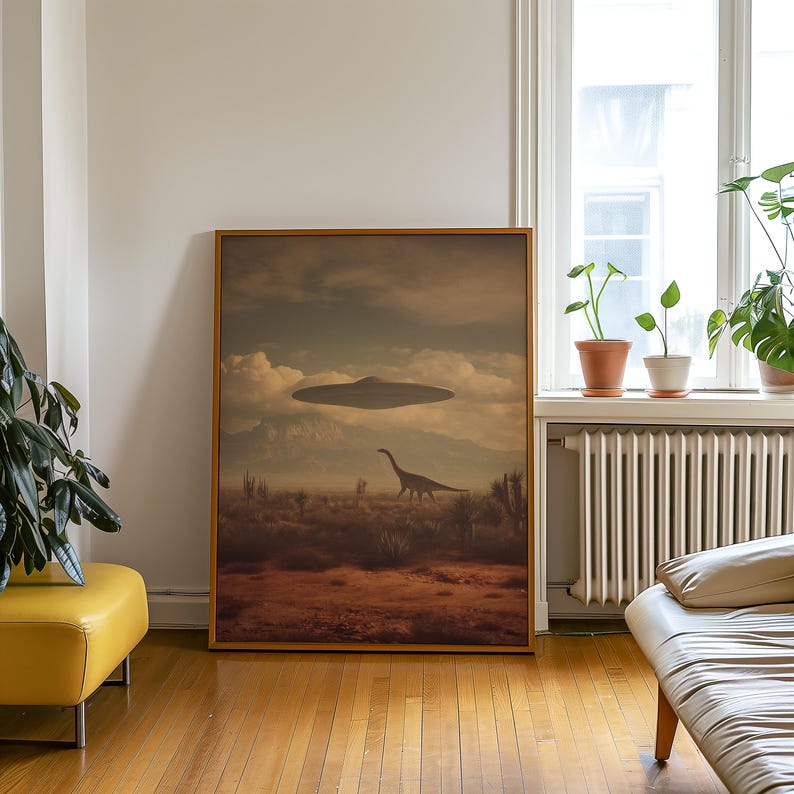 May include: A framed art print depicts a surreal landscape with a dinosaur and a UFO hovering above. The scene is set in a desert environment with mountains in the background. The artwork has a vintage, sepia-toned aesthetic.