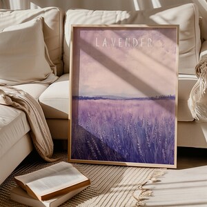 May include: A framed print of a lavender field with the word "LAVENDER" in white text at the top. The field is a soft purple color with a light pink sky in the background.