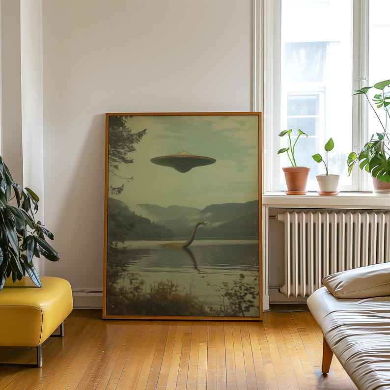 K&ouml;nnte beinhalten: Ein gerahmter Druck einer gr&uuml;nen und braunen Landschaft mit einem See, einem gro&szlig;en Seeungeheuer und einer fliegenden Untertasse am Himmel.