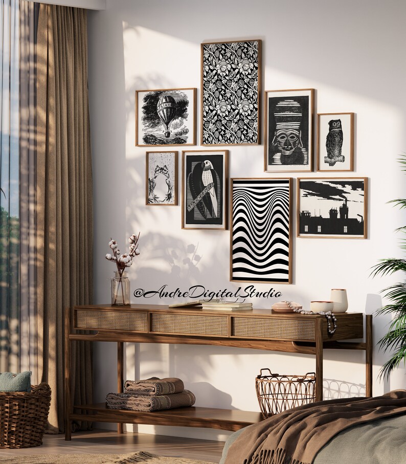 Puede incluir: Una pared de galer&iacute;a en blanco y negro con varias estampas enmarcadas, que incluyen un globo aerost&aacute;tico, un p&aacute;jaro, un patr&oacute;n geom&eacute;trico y una vista de la ciudad. Las estampas est&aacute;n dispuestas en una pared blanca sobre una mesa consola de madera con una tapa de rat&aacute;n tejido y una cesta tejida.
