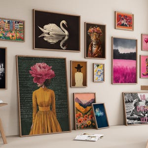 May include: A gallery wall featuring various framed art prints including a swan, a chandelier, a person with a large pink flower head, a leopard, a pink landscape, a cowboy boot, and a black and white beach scene with the text La Dolce Vita.