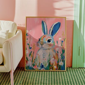 May include: A colorful painting of a rabbit with blue ears and a rainbow-colored body. The rabbit is surrounded by flowers and greenery, and the background is a soft pink.