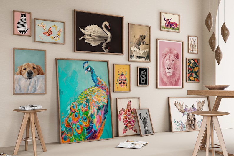 May include: A gallery wall featuring a variety of framed animal prints, including a peacock, a lion, a swan, a turtle, a donkey, a moose, a cat, a butterfly, a beetle, a snake, a dog, and an elephant. The prints are arranged in a grid pattern on a white wall.