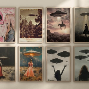 May include: A collection of eight framed art prints featuring retro-style illustrations of UFOs and figures. The artwork includes scenes of alien encounters, a cowboy on horseback, and figures in fields. One print features the text "WEIRD HABITS".