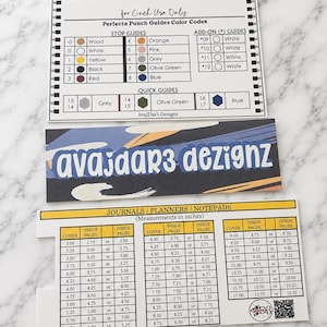 May include: A white rectangular reference card titled Perfecta Punch Guides Color Codes with tables for stop guides, add-on guides, and quick guides. Below it is a branded card for AvaJdar3 Dezignz and a measurement chart for journals and planners.