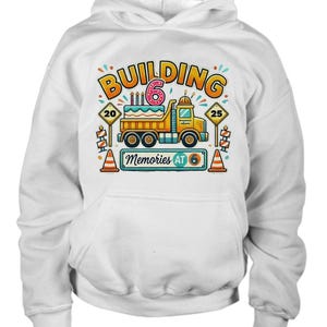 May include: White hoodie with a graphic of a yellow dump truck with a birthday cake on the back. The truck has a number 6 on the side and the text "Building Memories at 6".