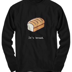 Może przedstawiać: Czarny t-shirt z długim rękawem z kreskówkową ilustracją bochenka chleba i tekstem "It's bread."