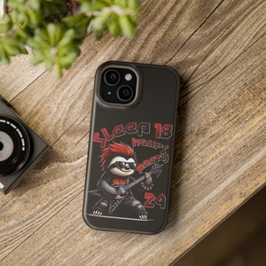 May include: Black phone case featuring a cartoon sloth with a red mohawk, sunglasses, and a guitar. The text on the case reads "Sleep 18 hours Party 24". The case is on a wooden surface.