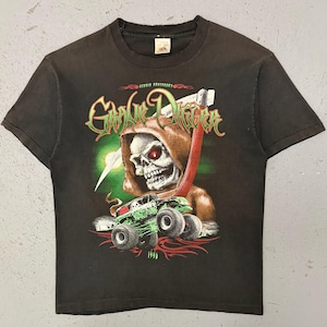May include: Black t-shirt with a graphic of a skull in a hooded cloak with red eyes, holding a scythe. A green monster truck is below the skull. The text "Grave Digger" is above the skull.
