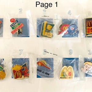 Op de afbeelding: Een verzameling van tien McDonald's promotiepinnen, elk in een doorzichtige plastic zak. De pinnen hebben verschillende ontwerpen, waaronder het Monopoly-spel, het McDonald's-logo en het Barbie-logo. De tekst "Page 1" staat bovenaan.