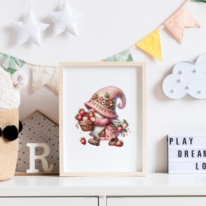 May include: A framed print featuring a whimsical gnome illustration. The gnome, dressed in pink and adorned with flowers, carries a basket of strawberries. The artwork is set against a white background, with decorative elements like stars and a banner.