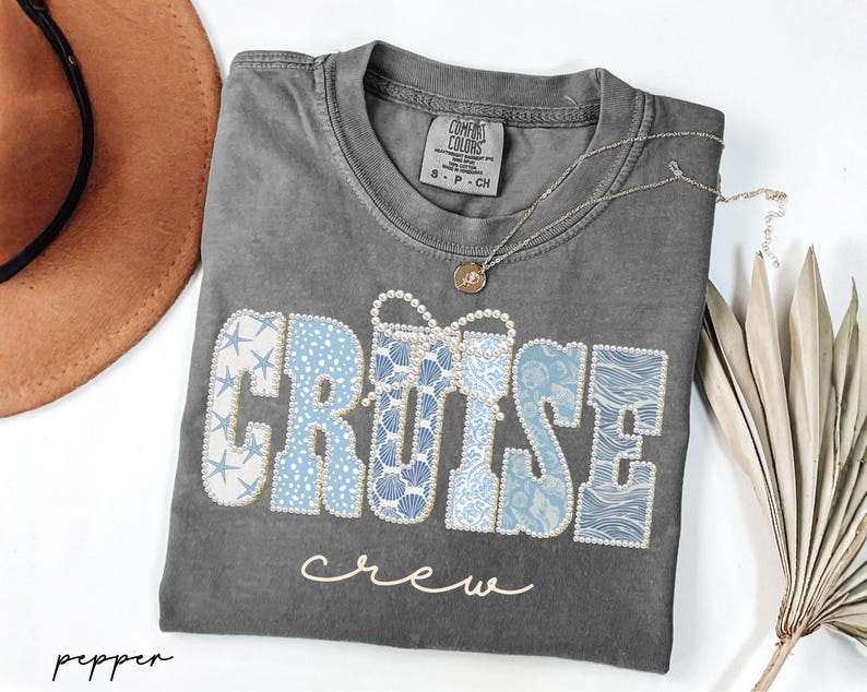 Puede incluir: Una camiseta gris Comfort Colors con las palabras "CRUISE crew" en una fuente decorativa. La palabra "CRUISE" est&aacute; en un dise&ntilde;o n&aacute;utico azul y blanco, y la palabra "crew" est&aacute; en cursiva.