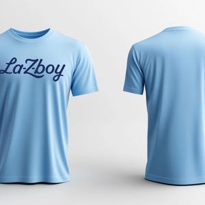 May include: Light blue t-shirt with the word "La-Zboy" in dark blue script across the chest. The image shows both the front and back of the shirt, highlighting its simple design and color.