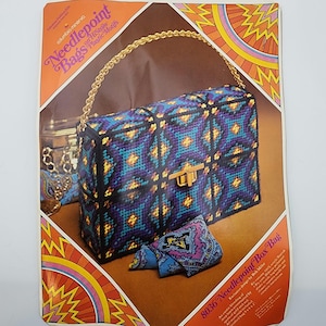 May include: A vintage needlepoint box bag kit with a geometric pattern in teal, purple, and gold. The bag has a gold chain handle and a gold clasp. The kit includes a small matching pillow. The text "Needlepoint Bags" is visible.