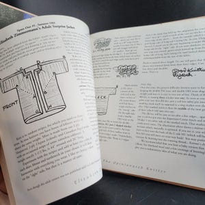 May include: Open book with a black and white diagram of a jacket, labeled "FRONT" and "BACK". Text includes instructions for knitting the "Adult Surprise Jacket" by Elizabeth Zimmermann, with measurements in inches.