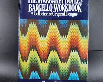 May include: A hardcover book titled "The Margaret Boyles Bargello Workbook" with a blue cover. The cover features white text and a colorful, zig-zag pattern in shades of brown, orange, yellow, green, and blue. The author's name, Margaret Boyles, is at the bottom.