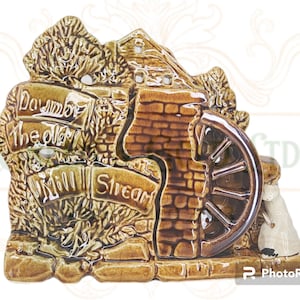 May include: A ceramic figurine of a watermill with a brown and green glaze. The mill has a water wheel and a sign that reads "Down by the Old Mill Stream".