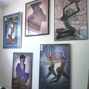 May include: Five framed art prints hang on a white wall. The prints depict stylized figures in various poses, with a color palette including blues, browns, and pinks. The artwork appears to be batik or similar textile art, with a focus on human form.