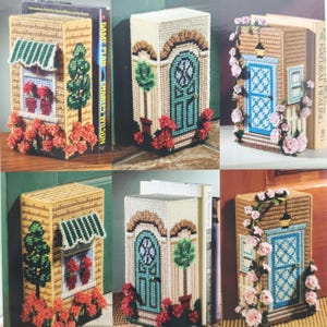 Peut inclure: Six protège-livres en canevas plastique représentant des façades de maisons. Les motifs incluent une fenêtre avec un auvent vert et des fleurs rouges, une porte turquoise avec un topiaire et une porte bleue ornée de roses roses.