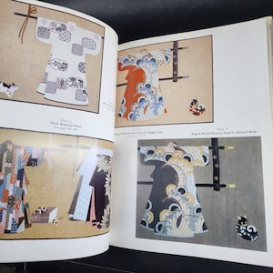 May include: Open book with illustrations of kimono panels. The panels feature various designs, including wave patterns and geometric shapes. The color palette includes white, blue, orange, and black. The text on the page reads "Three Kimonos Panel" and "Wagon Wheels Kimono Panel".