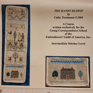 May include: An image of a cross-stitch project with the text "THE HANDY HUSWIF" and "Cathy Trostmann ©2004". The project features various embroidered motifs, including trees, houses, and decorative borders. The text "Intermediate Stitcher Level" is also visible.