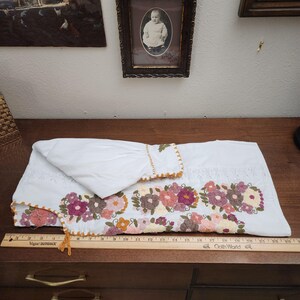 Puede incluir: Una taza de cer&aacute;mica blanca con asa negra y el texto "But First, Coffee" en negrita negra. La taza se encuentra sobre un fondo borroso, sugiriendo un ambiente acogedor.