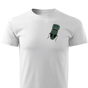 Op de afbeelding: Een wit T-shirt met een groene autoprint op de voorkant. De auto staat ondersteboven en heeft zwarte wielen.