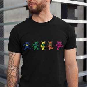 May include: A black t-shirt with a graphic of five dancing bears in rainbow colors. The bears are wearing hats and have different expressions.