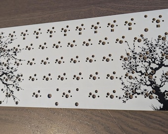 May include: White metal plate with a black and white design of two stylized trees. The plate has a grid of holes for mounting electronic components. The text "Panel Controller Test Board" is printed in the upper right corner.