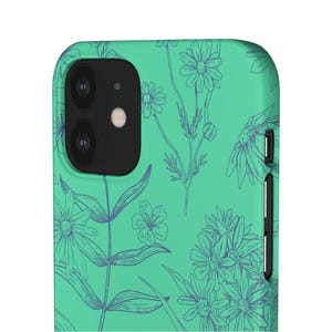 Könnte beinhalten: Eine türkisfarbene Handyhülle mit floralem Muster. Die Hülle zeigt ein sich wiederholendes Design aus blau gezeichneten Blumen und Blättern. Die Handyhülle hat einen Ausschnitt für Kamera und Blitz.