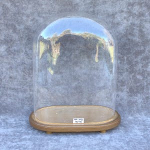 May include: A white ceramic mug with a black handle and the text "But First, Coffee" in a bold, black font. The mug is set against a blurred background, suggesting a cozy setting.